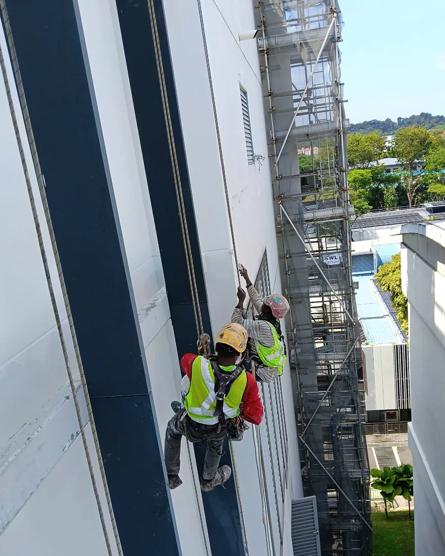 City Painters rope-access painters applying the first coat to a high-rise facade in Singapore