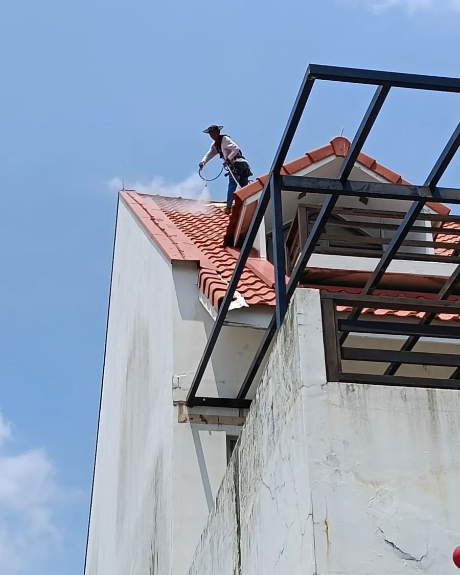 Roof coating work alongside a steel pergola frame on a Singapore property