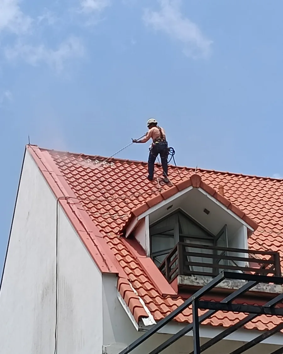 City Painters roofer spray-coating a tiled roof in Singapore