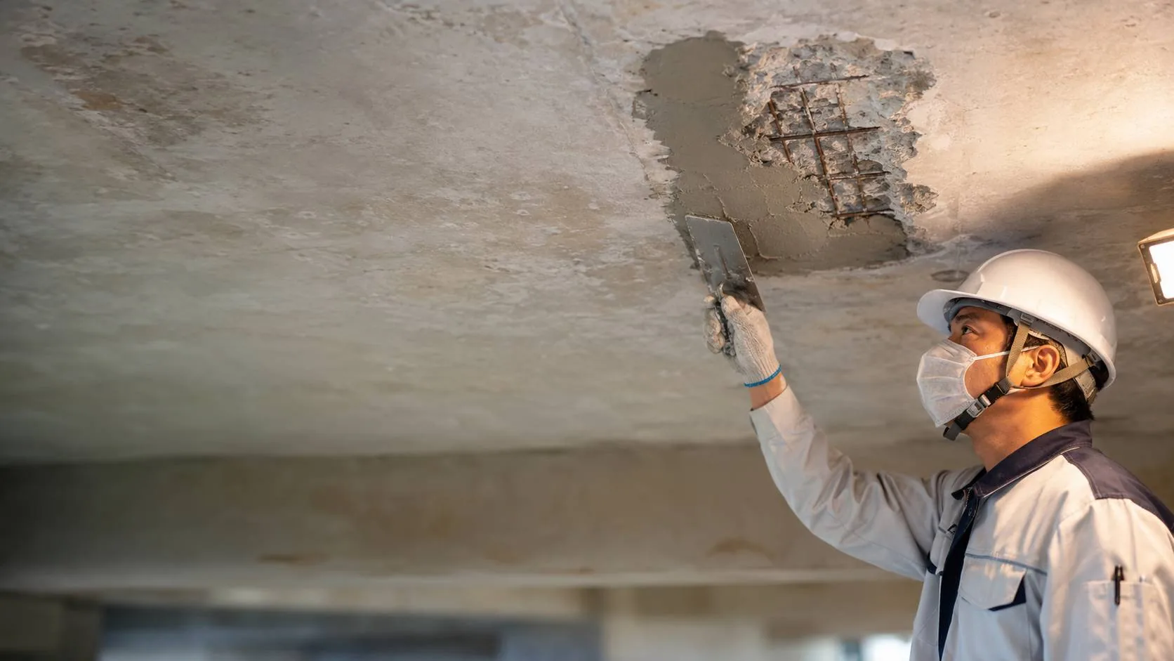 Specialist assessing an affected ceiling before mould treatment